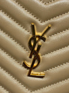 YSL logo charm on chevron-quilted tan leather bag with gold hardware