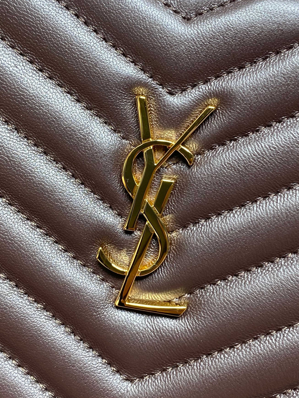 YSL logo hardware on dark brown quilted leather with chevron ridges