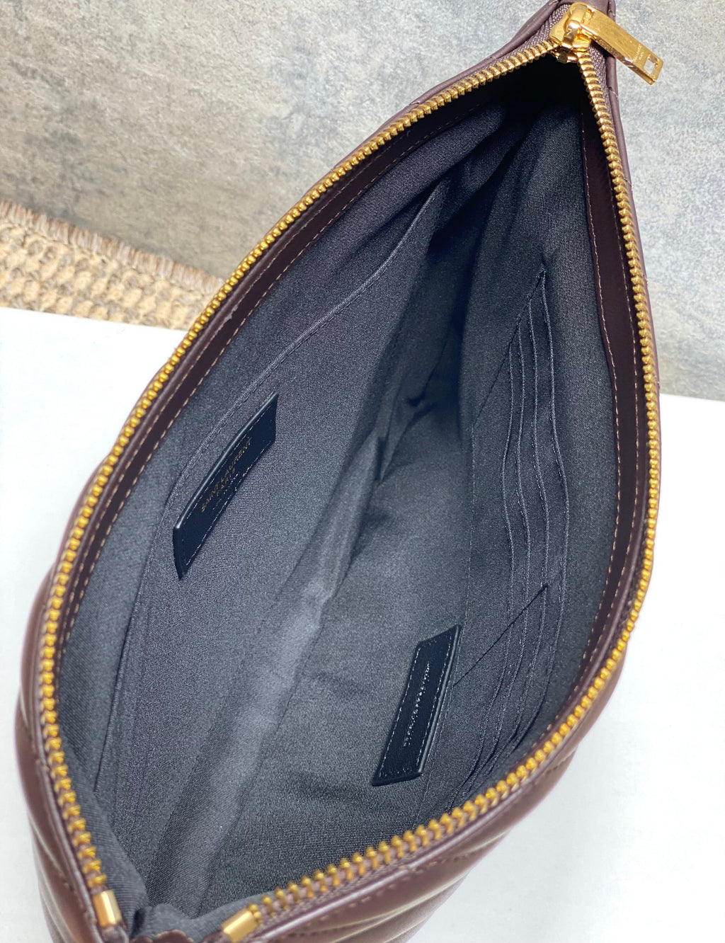 YSL small handbag open interior with dark lining, slip pockets, and gold zipper edge