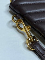 Gold clasp and dark brown leather wrist strap detail on YSL small handbag
