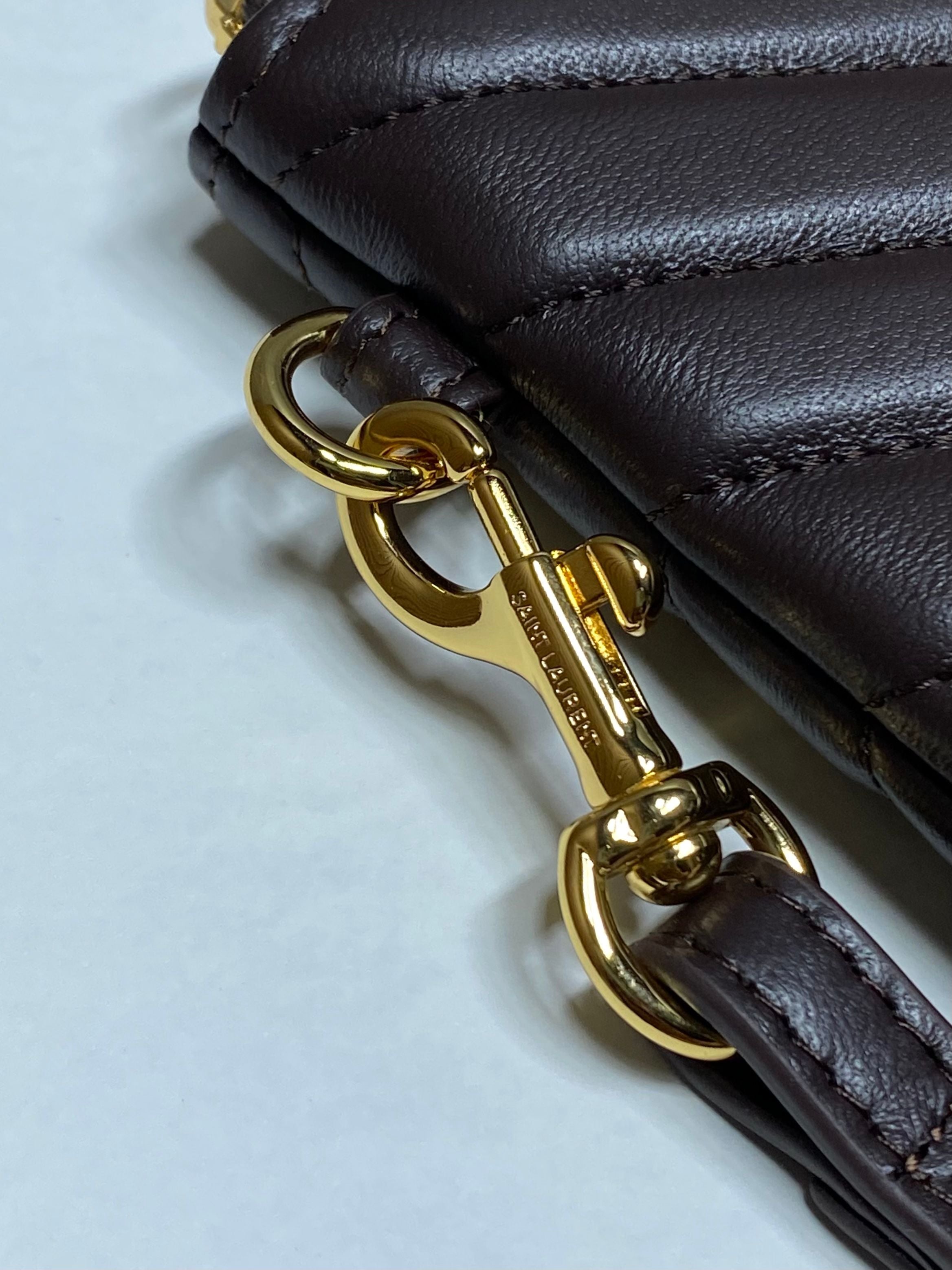 Gold-tone clasp and ring hardware on leather strap