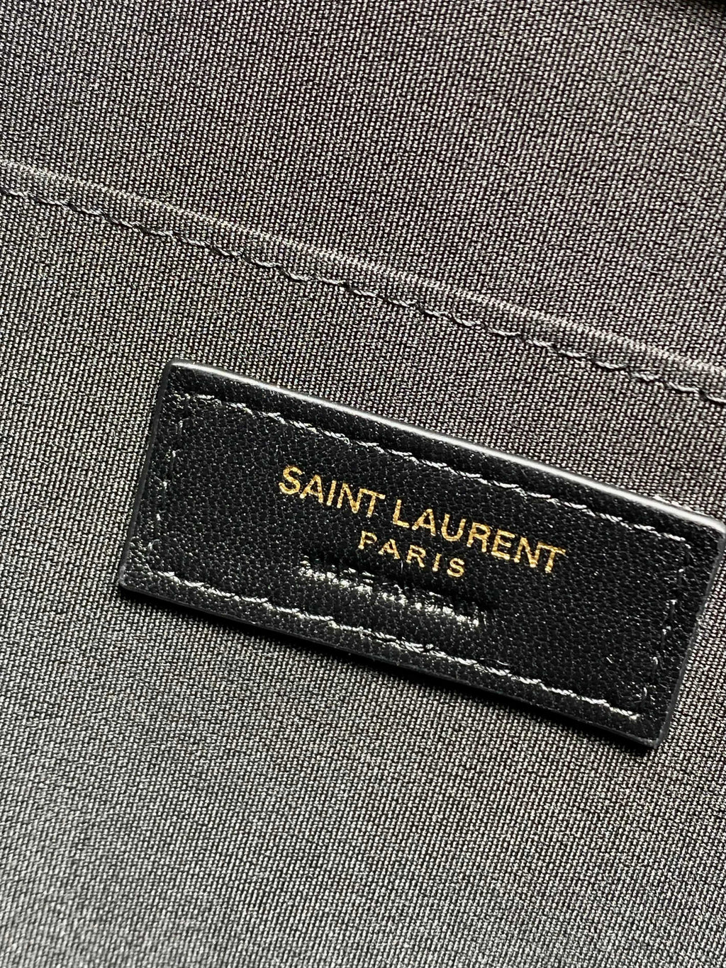 SAINT LAURENT Paris leather brand patch on dark interior fabric