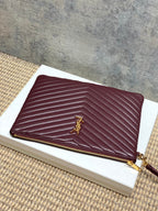 YSL burgundy quilted bag with gold YSL logo and gold zip closure along top edge.