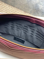 YSL bag interior view with pleated lining and gold zipper trim along the top edge.