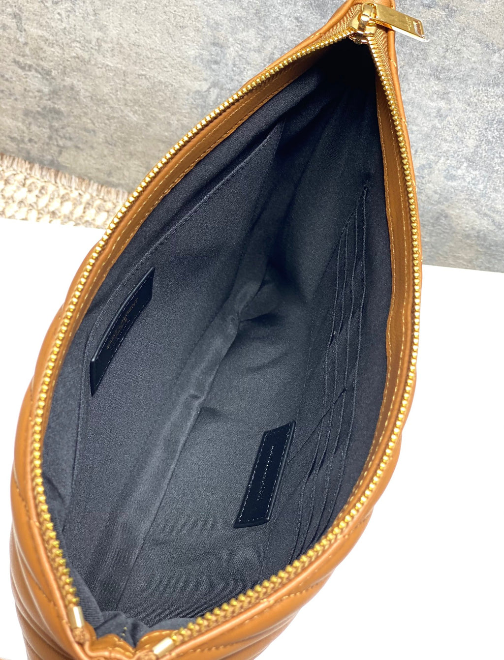 Inside view of YSL small bag with navy lining and zipper at top edge