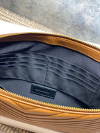 Inside view of YSL small quilted bag: navy lining, pocket, gold zipper edge