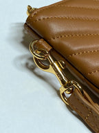 Brown leather bag with gold keyring clasp and swivel hardware near zipper