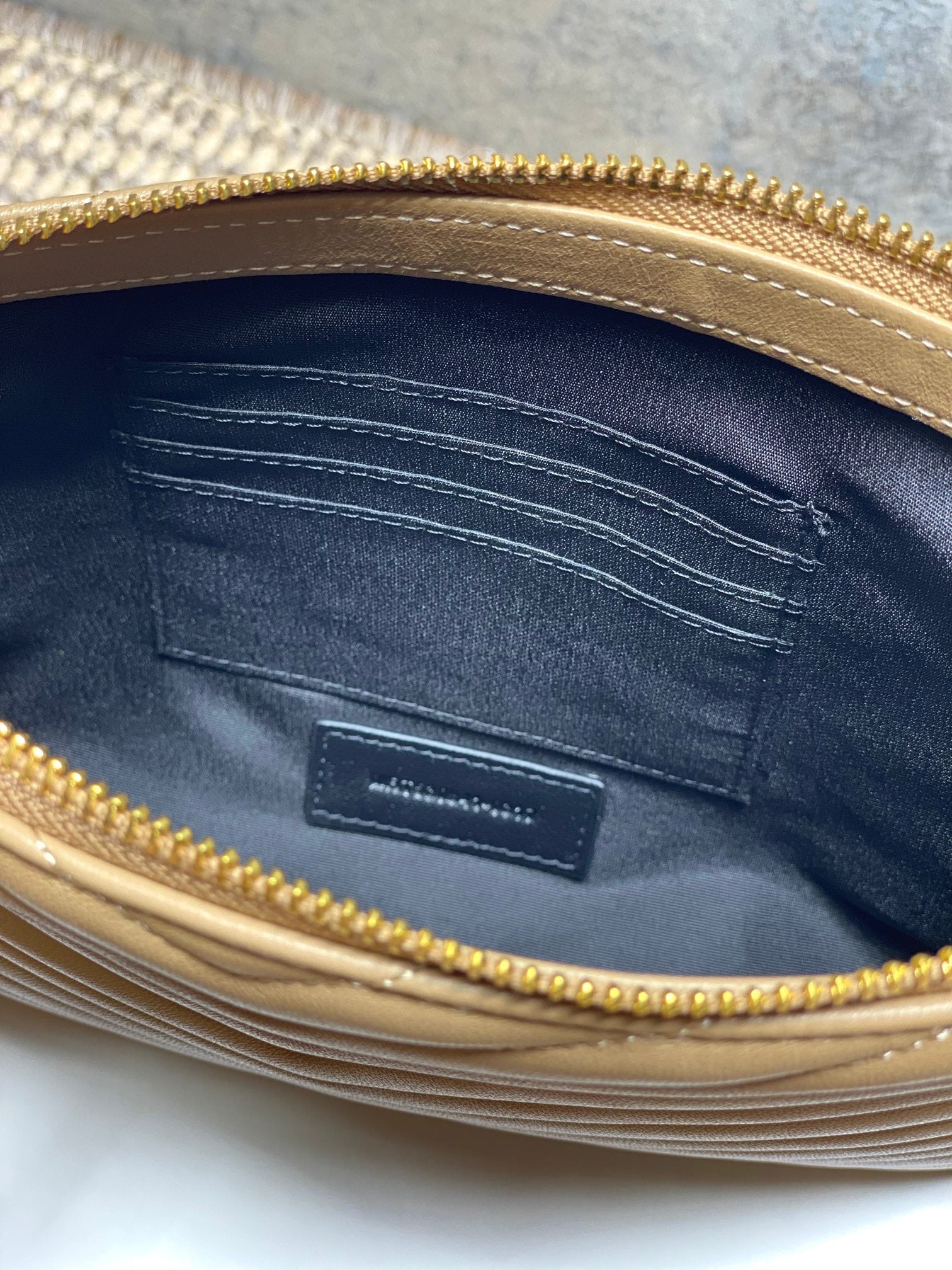 YSL small bag interior view with lining and patch pocket under gold zip edge