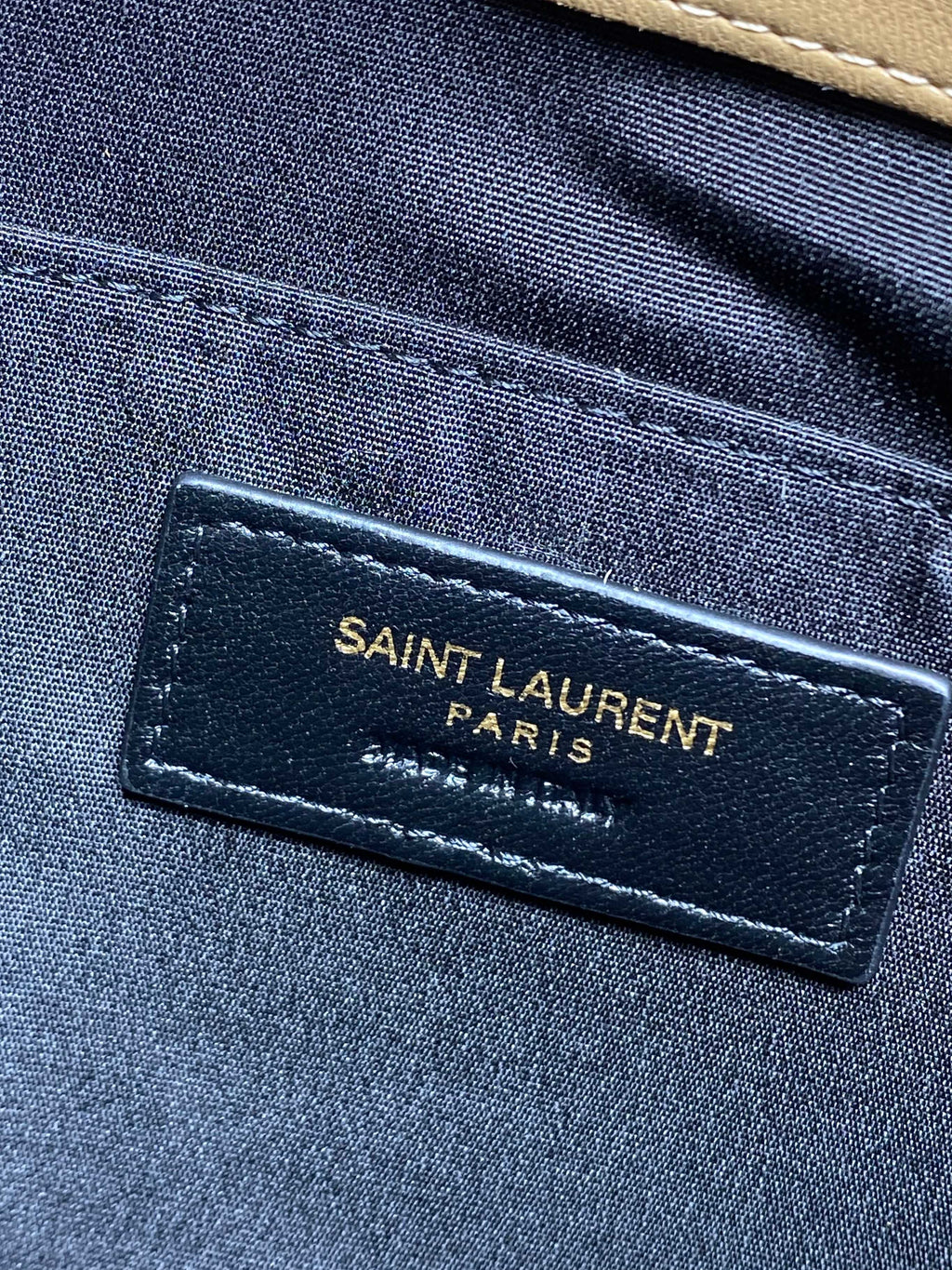 YSL bag interior label on blue lining reading SAINT LAURENT PARIS