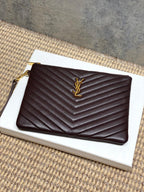 Small YSL quilted pouch bag in dark burgundy with gold YSL logo and zipper top.