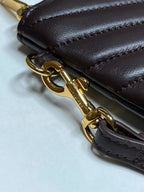Gold chain strap with clasp on dark leather quilted bag with YSL hardware.