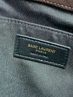 SAINT LAURENT Paris brand label on dark leather bag interior panel.
