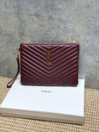 Burgundy quilted shoulder bag with gold-tone YSL-style logo on front and zip top