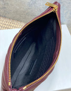 Black interior of burgundy small bag with zip opening and stitching