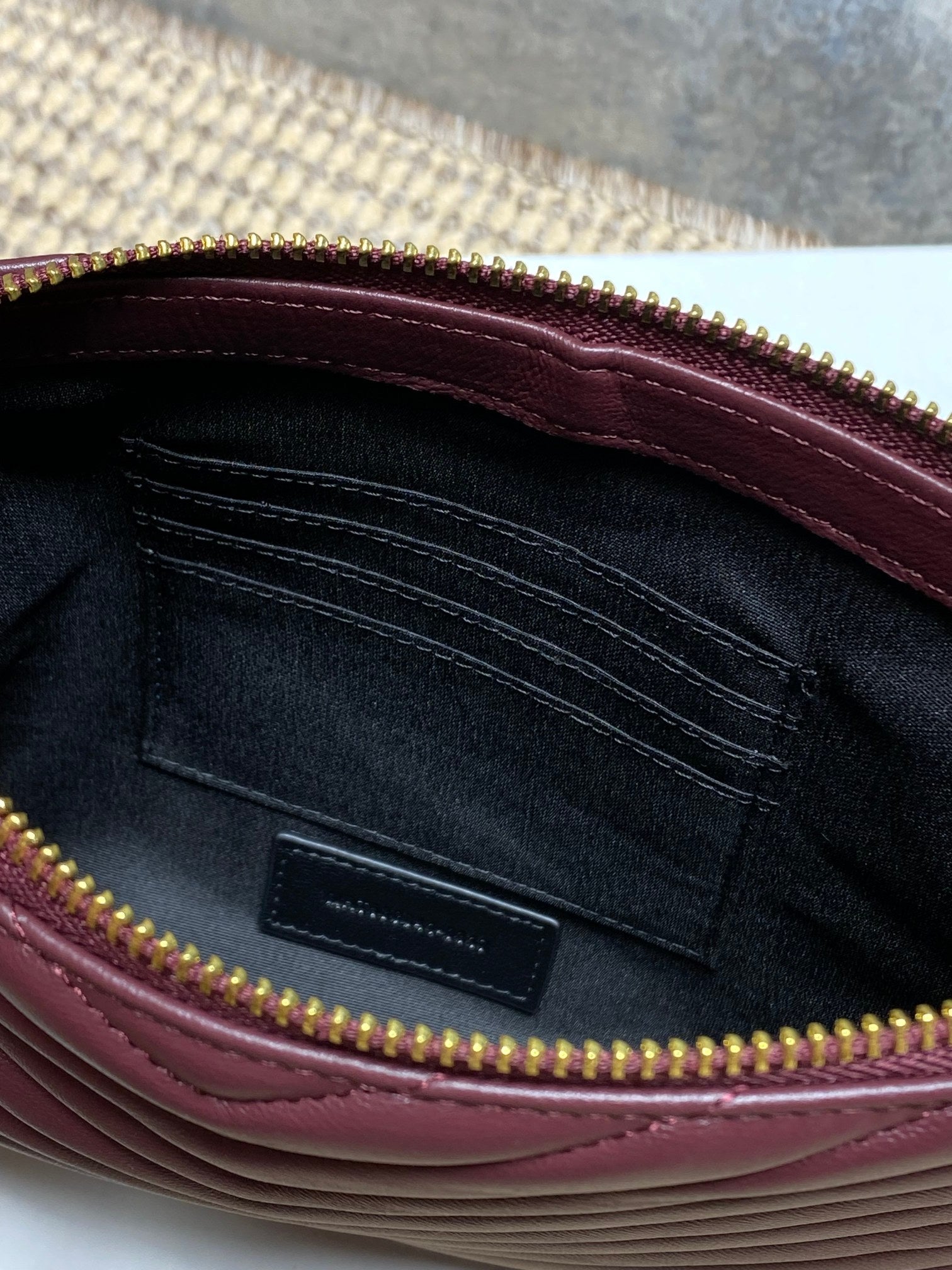 Burgundy interior lining with pocket and gold zipper trim