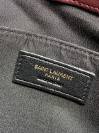 Fabric interior label reading “SAINT LAURENT PARIS” on gray lining