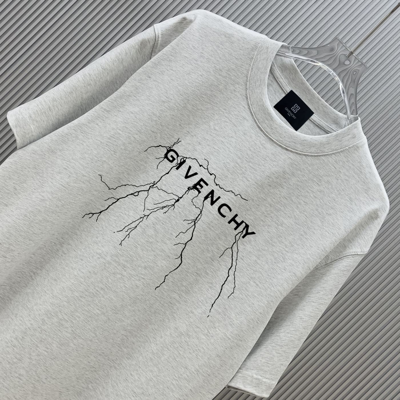Light gray Givenchy T-shirt close-up with tree-branch graphic and logo