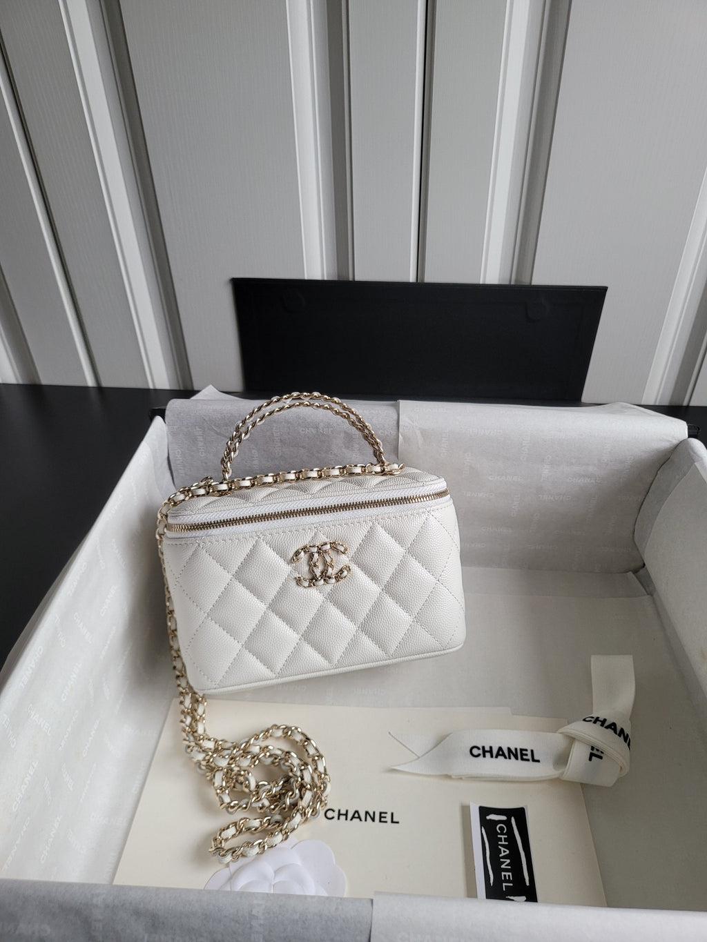 Chanel bag, white quilted leather with gold chain strap and top zip closure