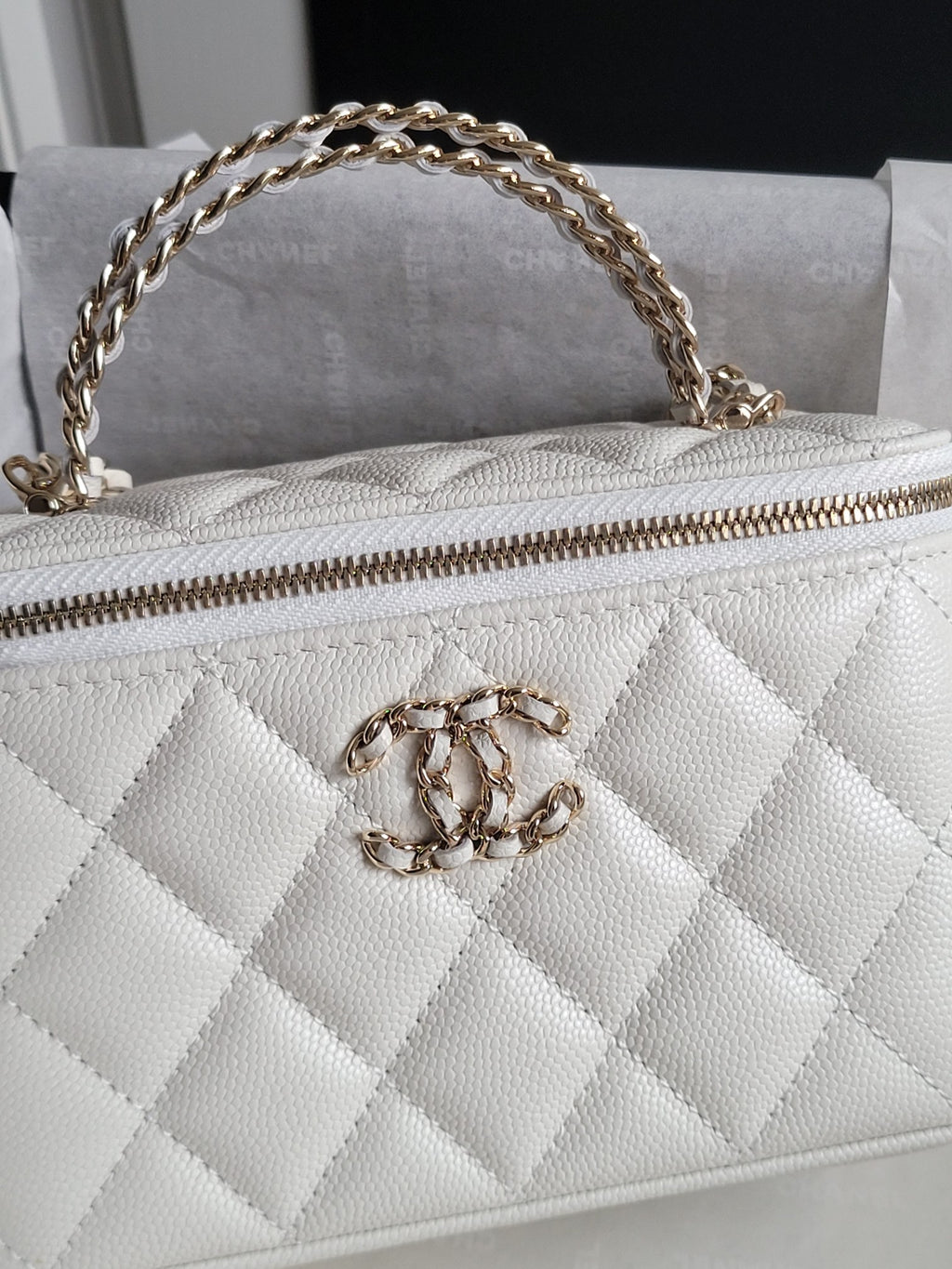 Chanel bag, white quilted leather with gold chain strap and front CC clasp close-up