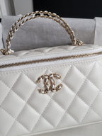 Chanel bag, white quilted leather with gold chain strap and front CC clasp close-up