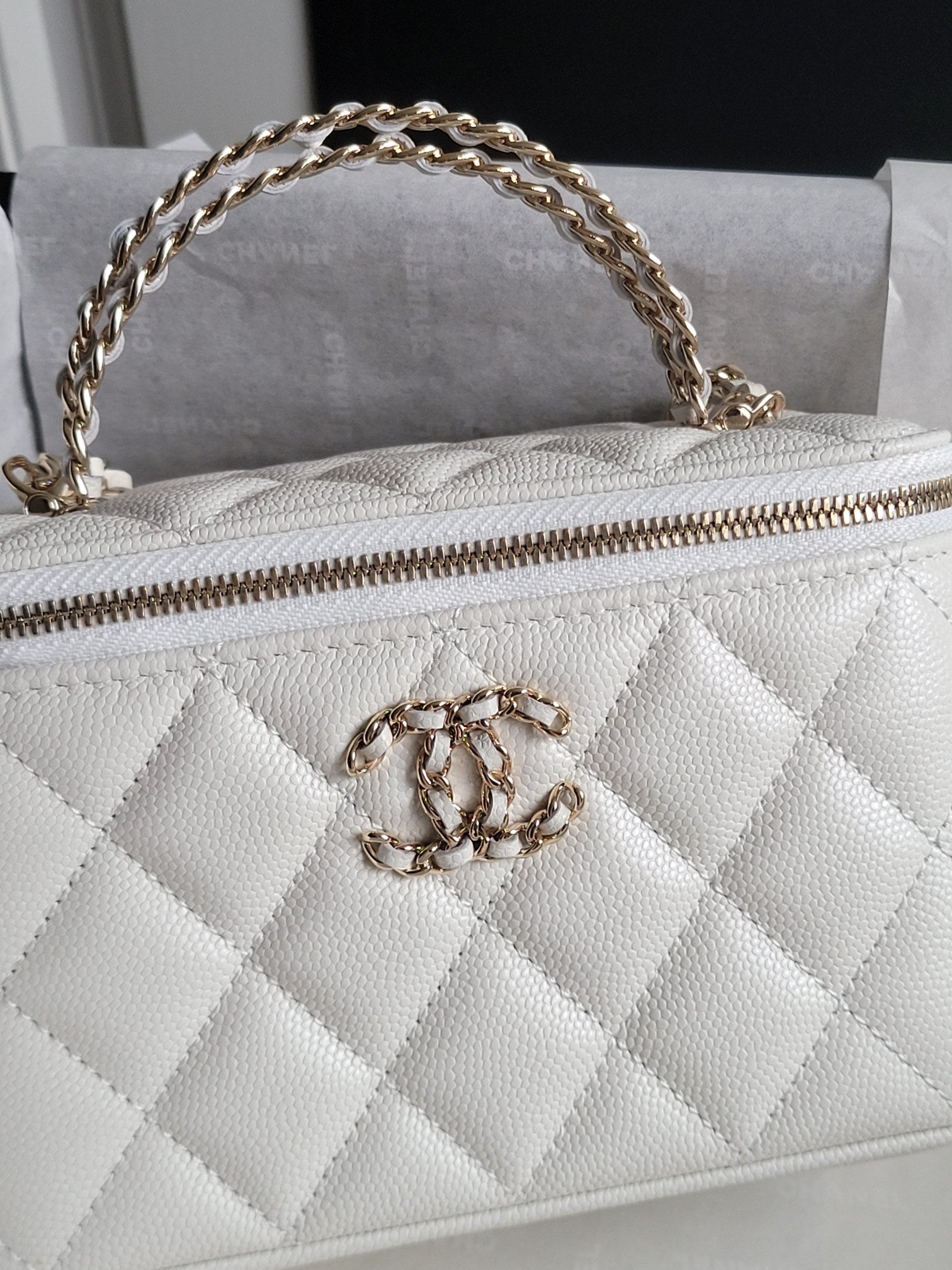 Chanel bag, white quilted leather with gold chain strap and front CC clasp close-up