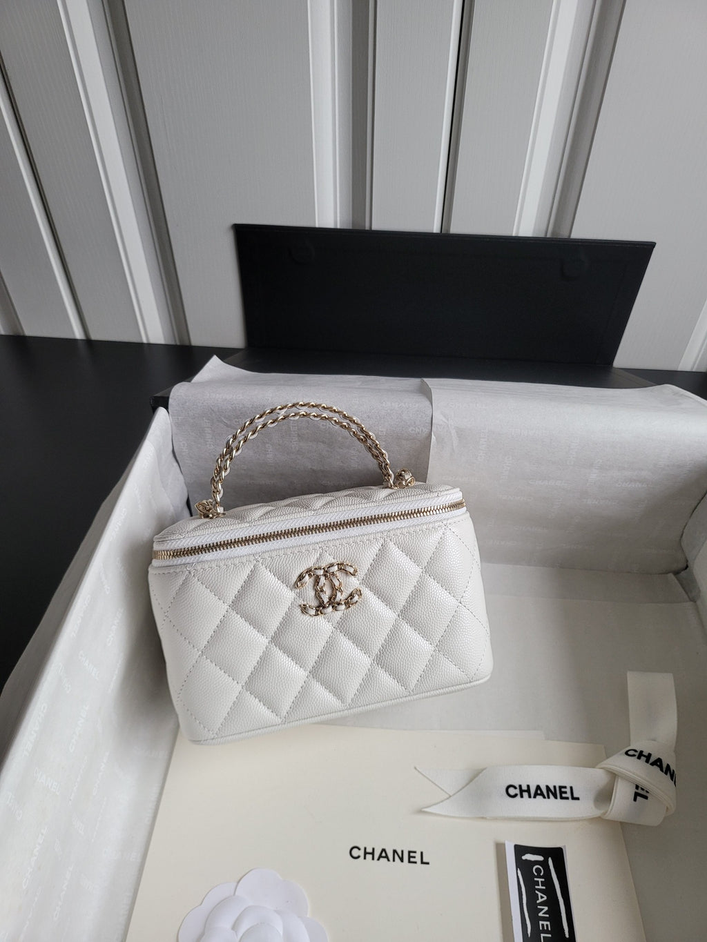 Chanel bag, white quilted leather with gold chain handle and top zip closure