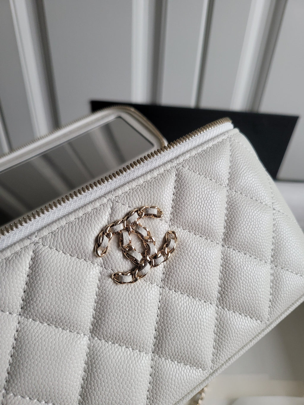 Chanel white quilted crossbody bag close-up with chain handle and zip edge