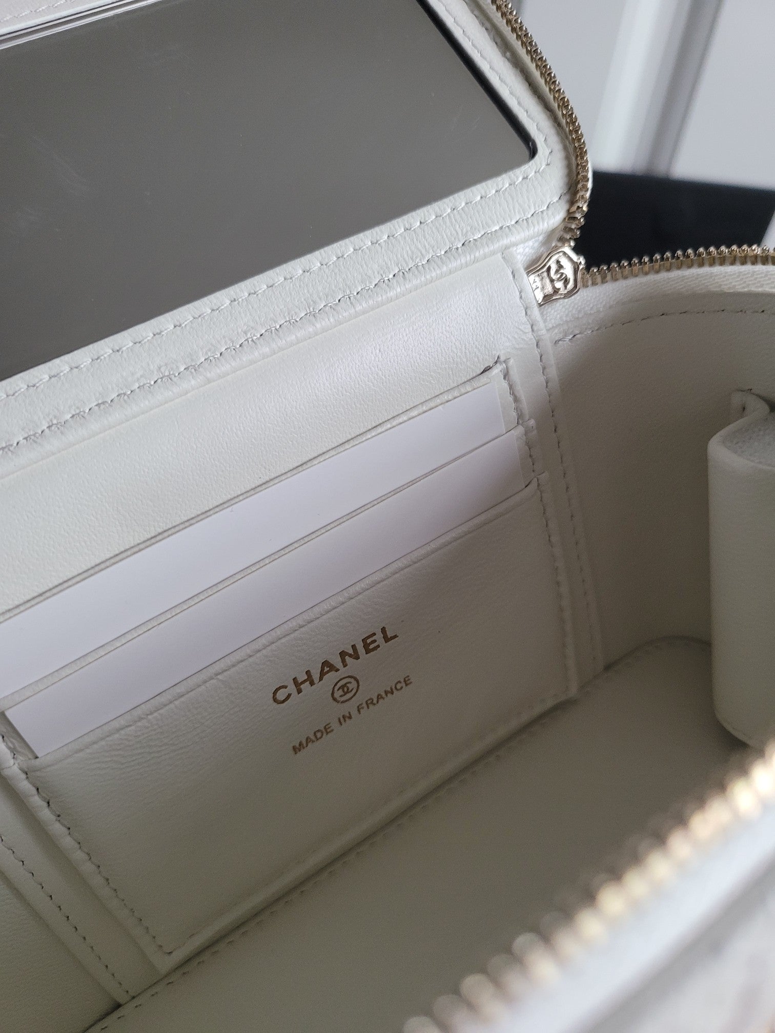 Chanel white quilted bag interior with card slots and zippered phone pocket