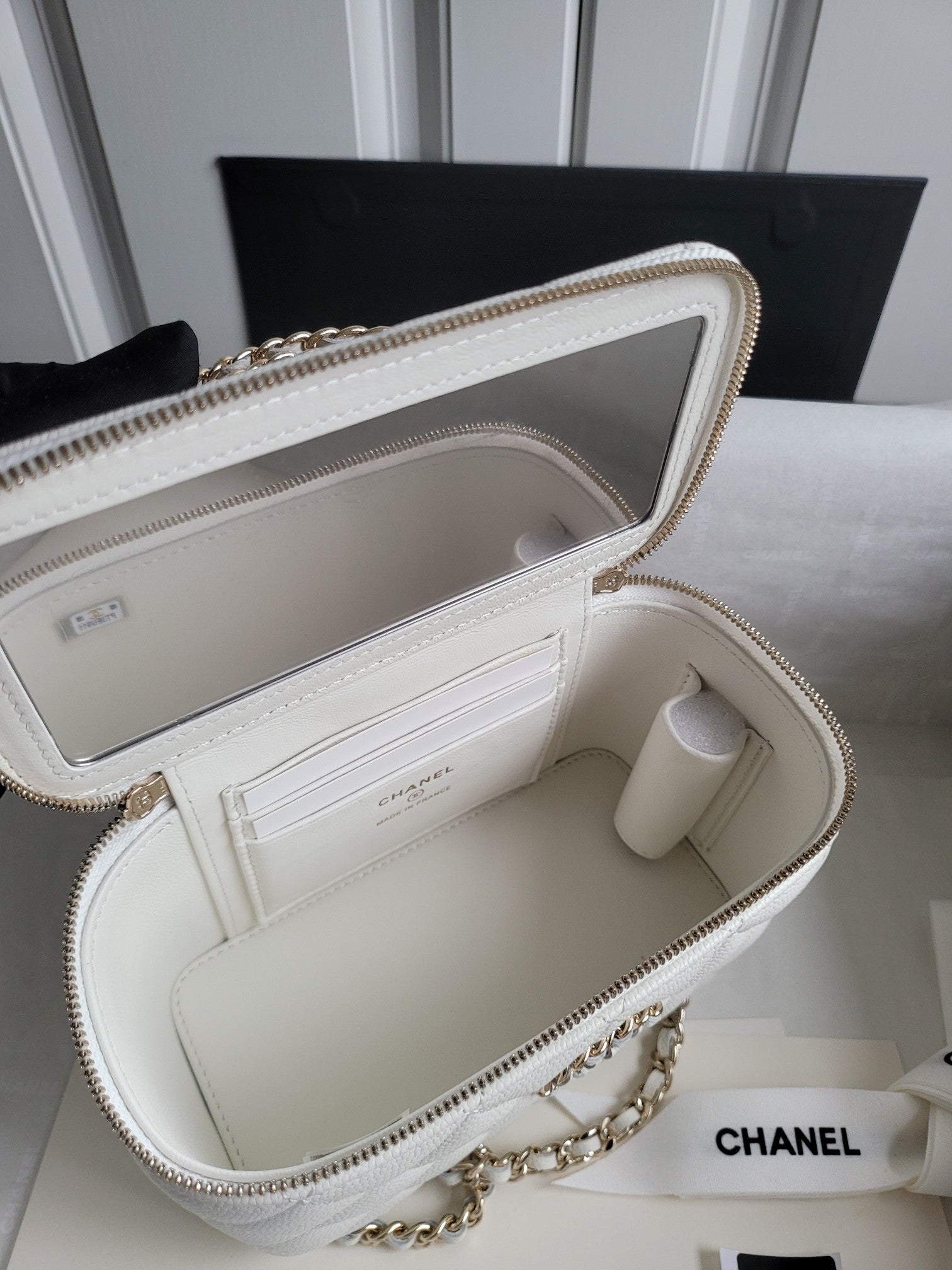Chanel white quilted bag open interior with card slots and phone pocket view