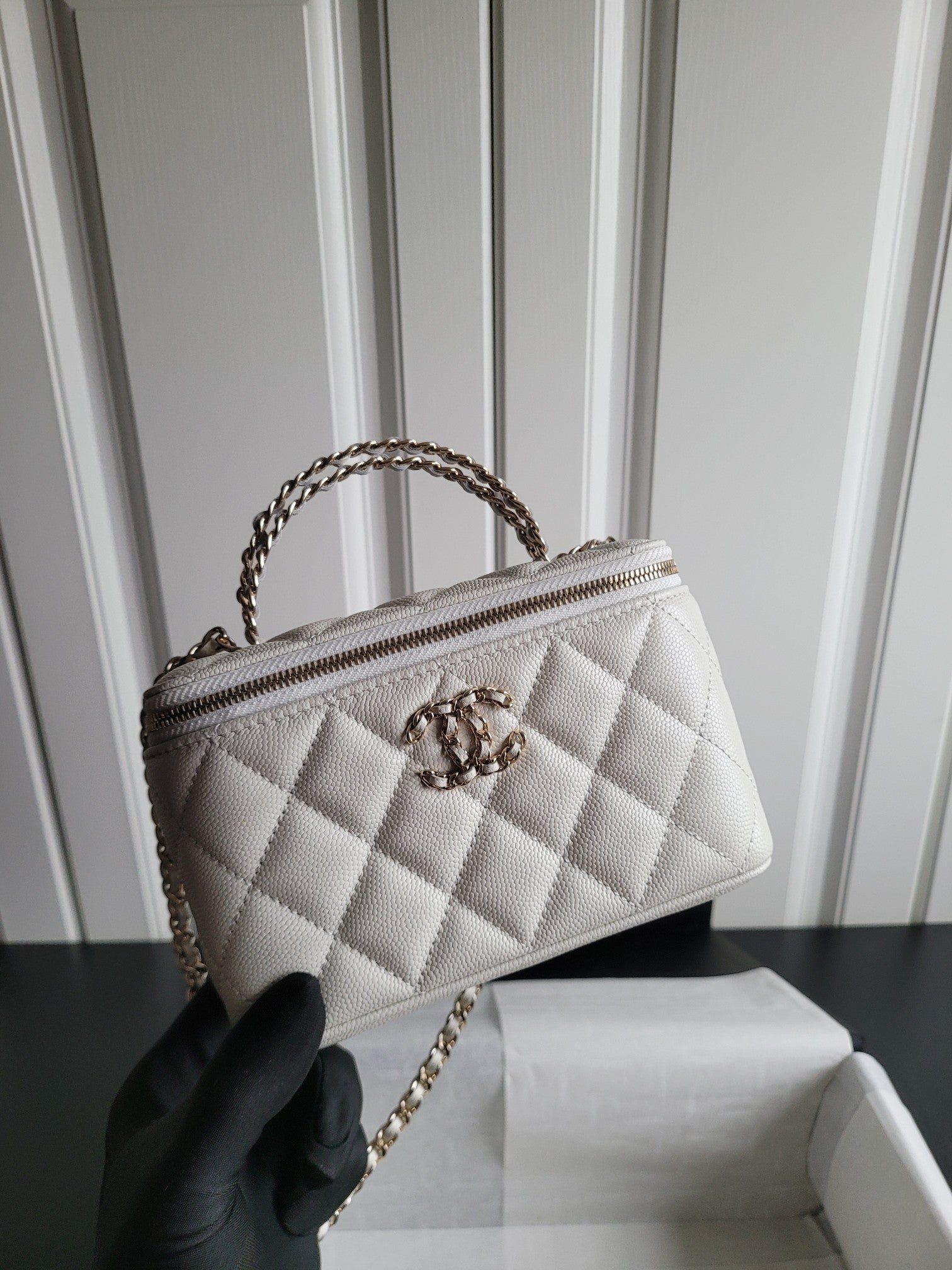 Chanel white quilted mini bag side view with chain handle and zip top
