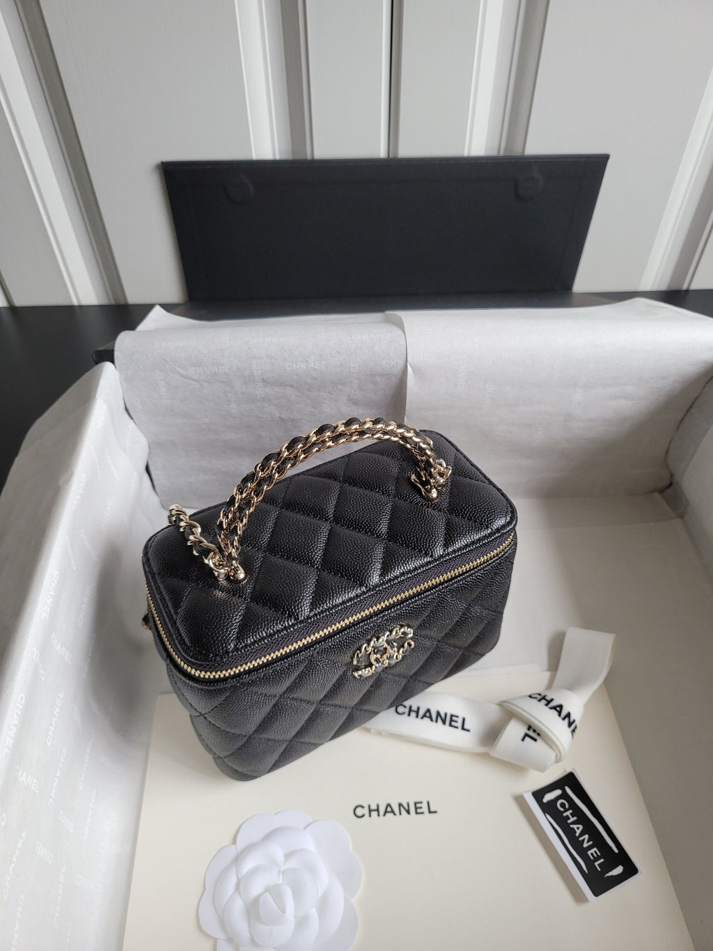 Chanel quilted mini handbag in dark color with chain strap and gold-tone logo