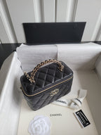 Chanel quilted mini handbag in dark color with chain strap and gold-tone logo