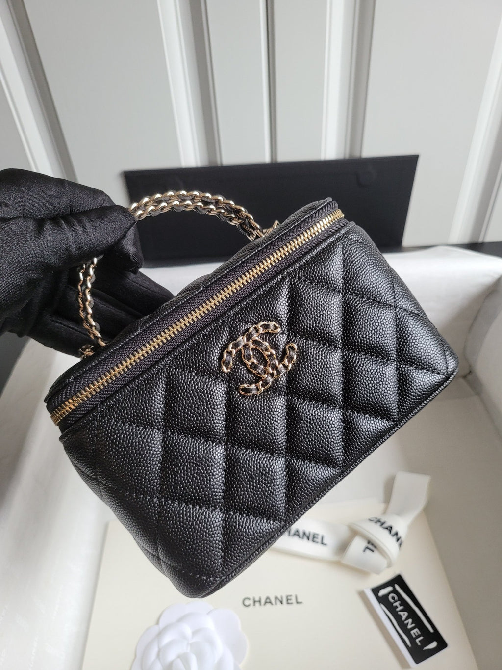 Chanel quilted mini handbag in dark color with gold-tone CC logo and chain strap
