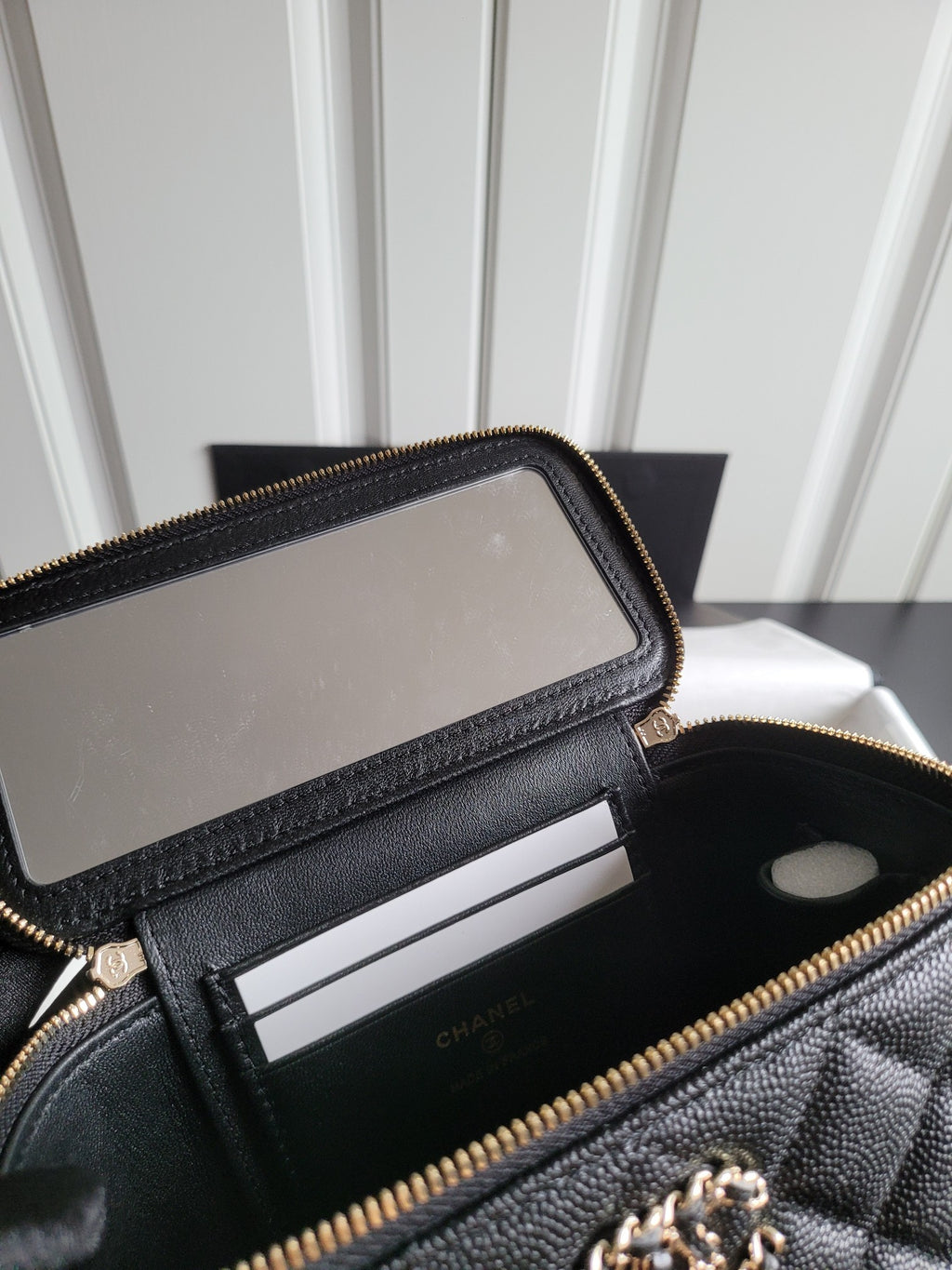 Chanel quilted bag interior with zipped pocket and card slot divider, gold zipper trim