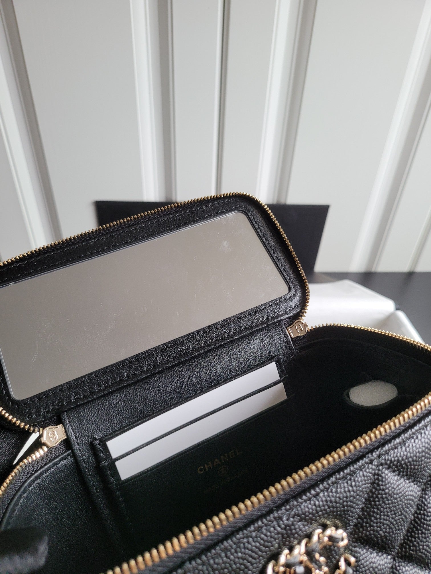 Chanel quilted bag interior with zipped pocket and card slot divider, gold zipper trim