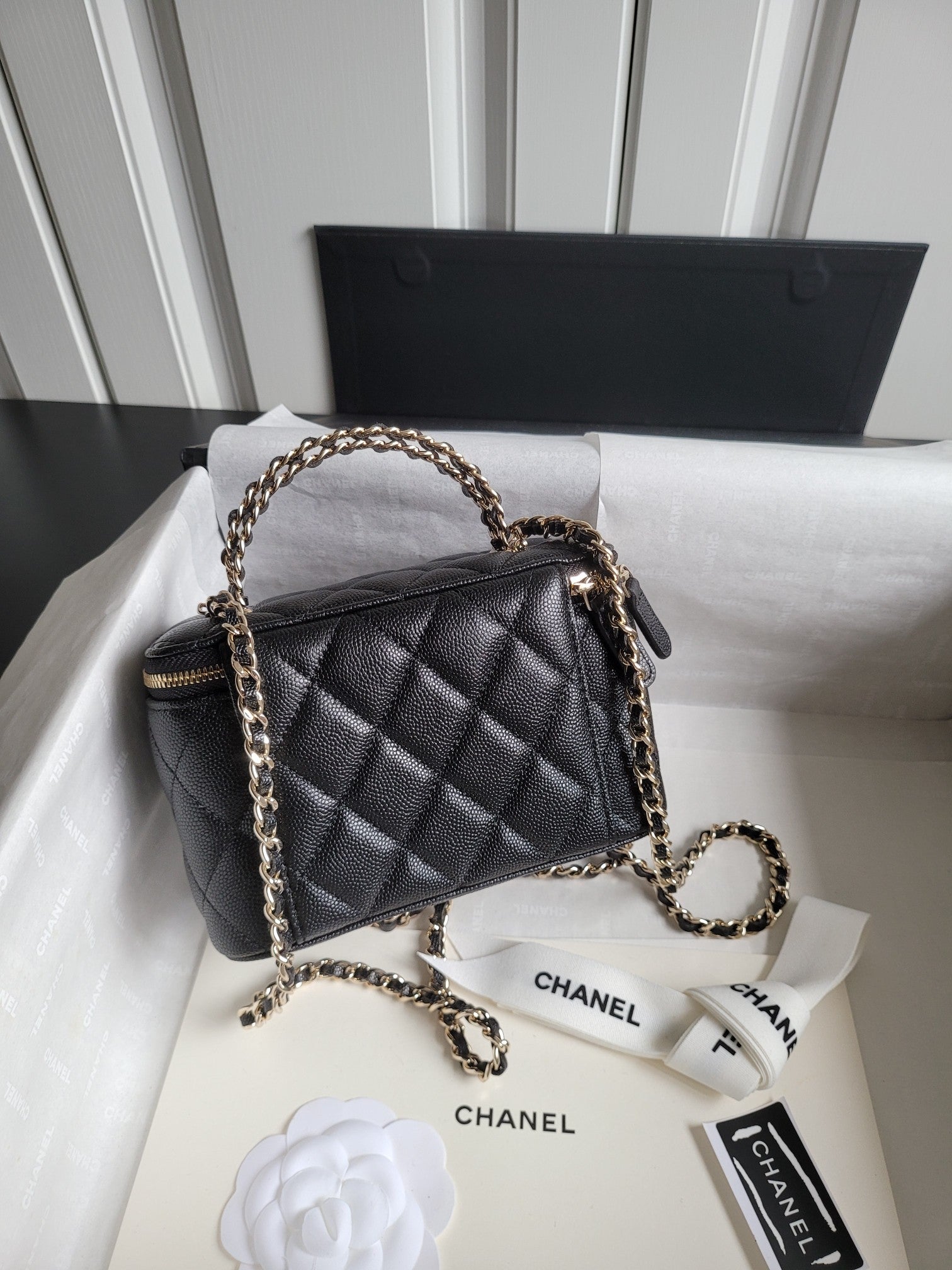 Chanel quilted crossbody bag with gold chain strap and front CC logo, top zip