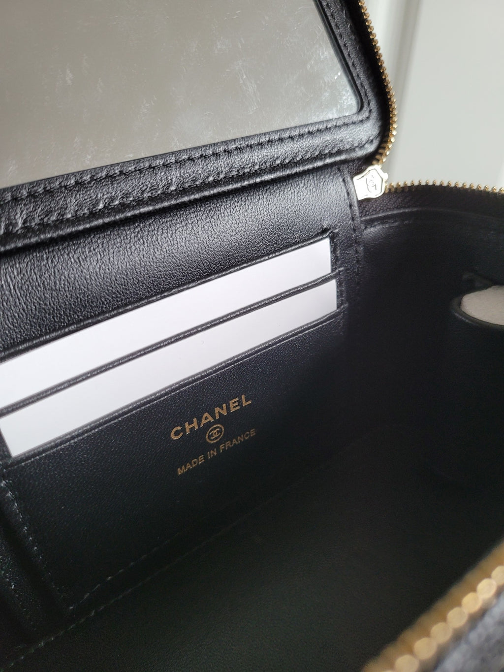 Chanel quilted bag interior with card slots and CHANEL logo label, dark leather