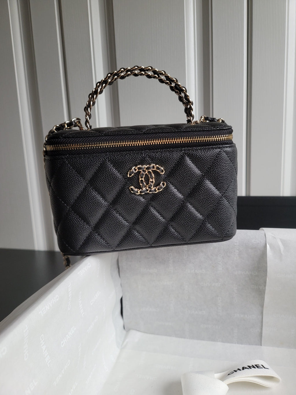 Quilted Chanel handbag in dark tone with gold chain handle and zip closure