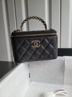Quilted Chanel handbag in dark tone with gold chain handle and zip closure