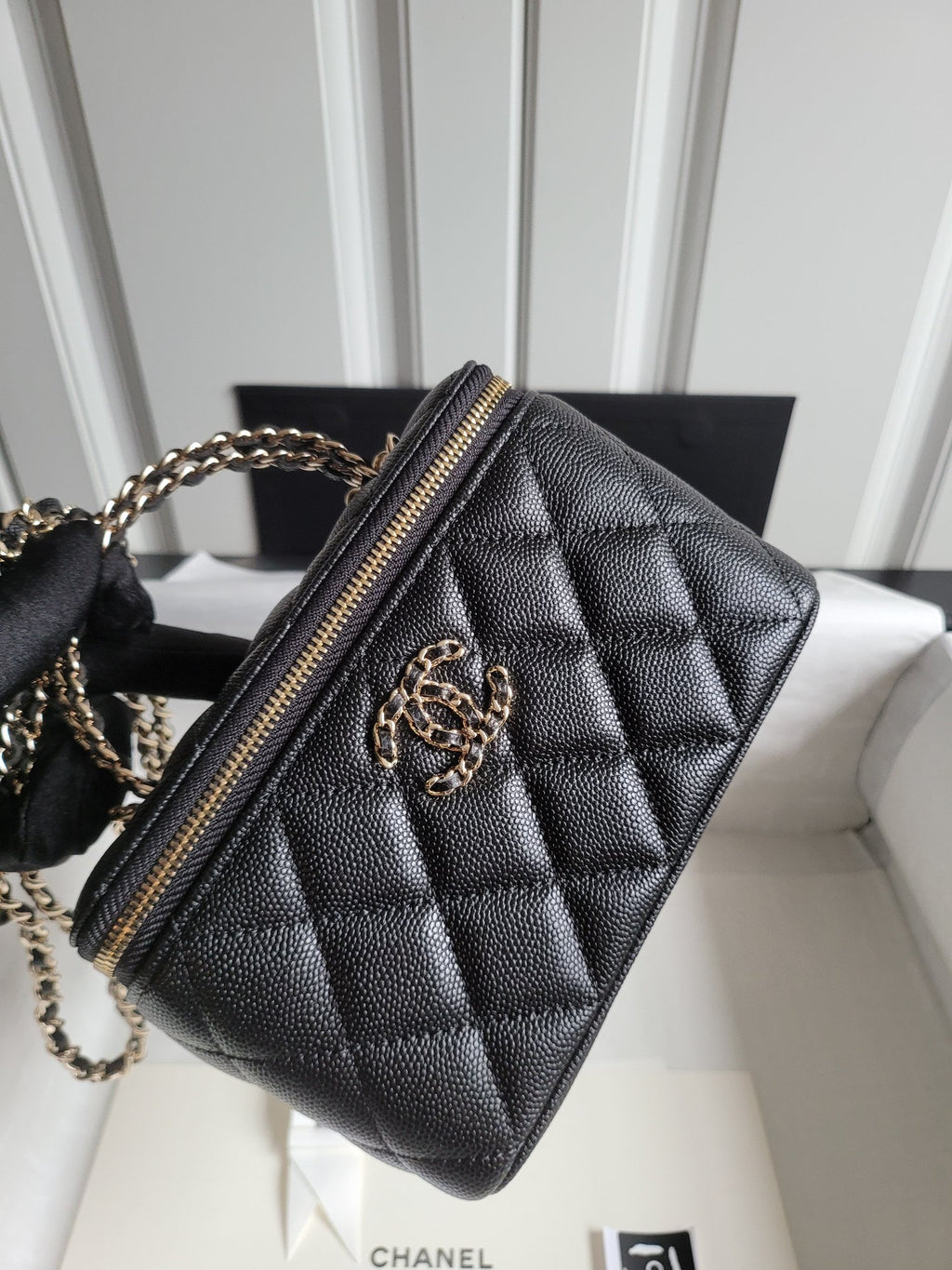 Chanel quilted mini bag with gold chain strap and front CC logo, zipped top
