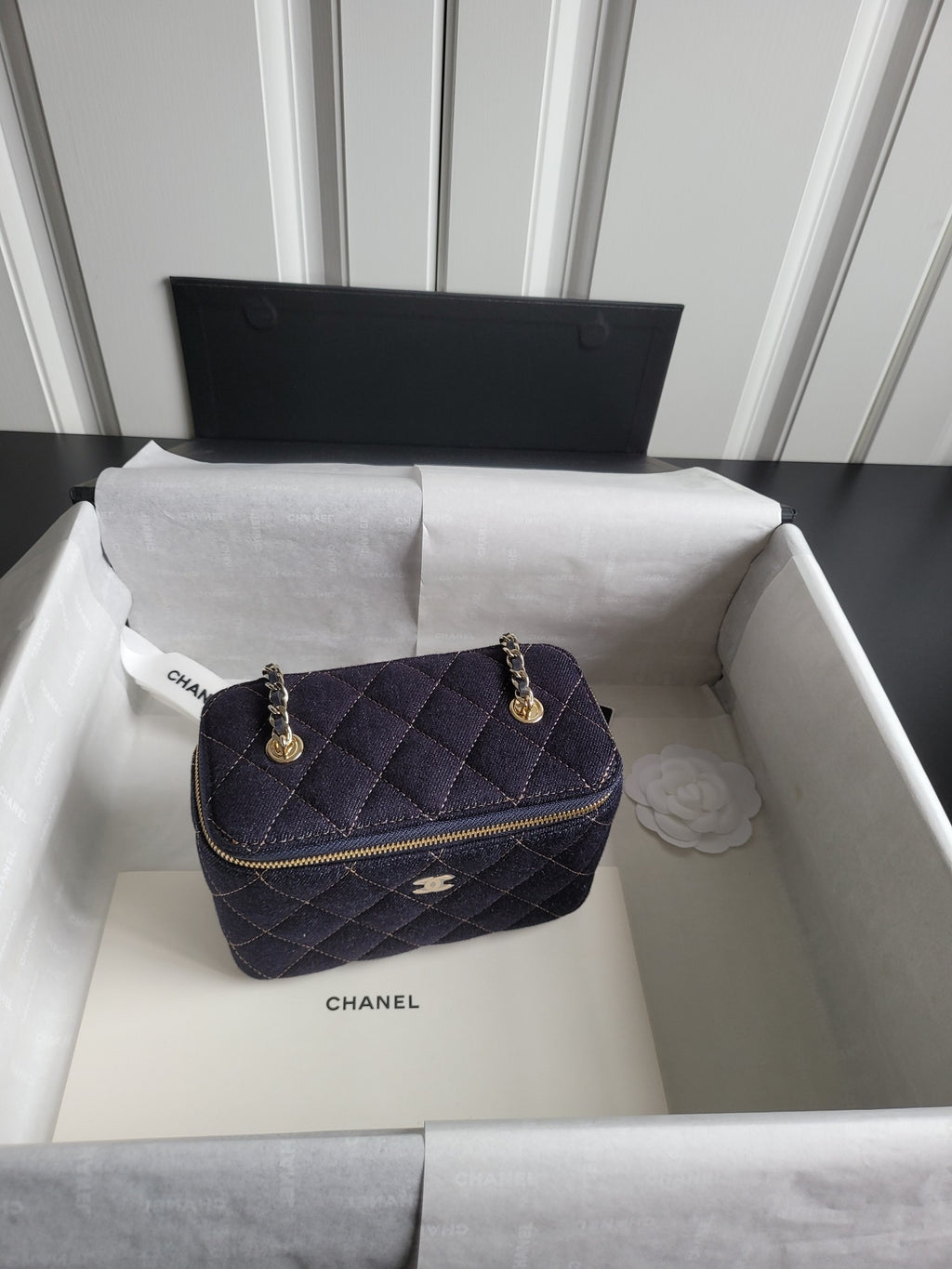 Chanel quilted navy shoulder bag with gold chain handles and zip closure