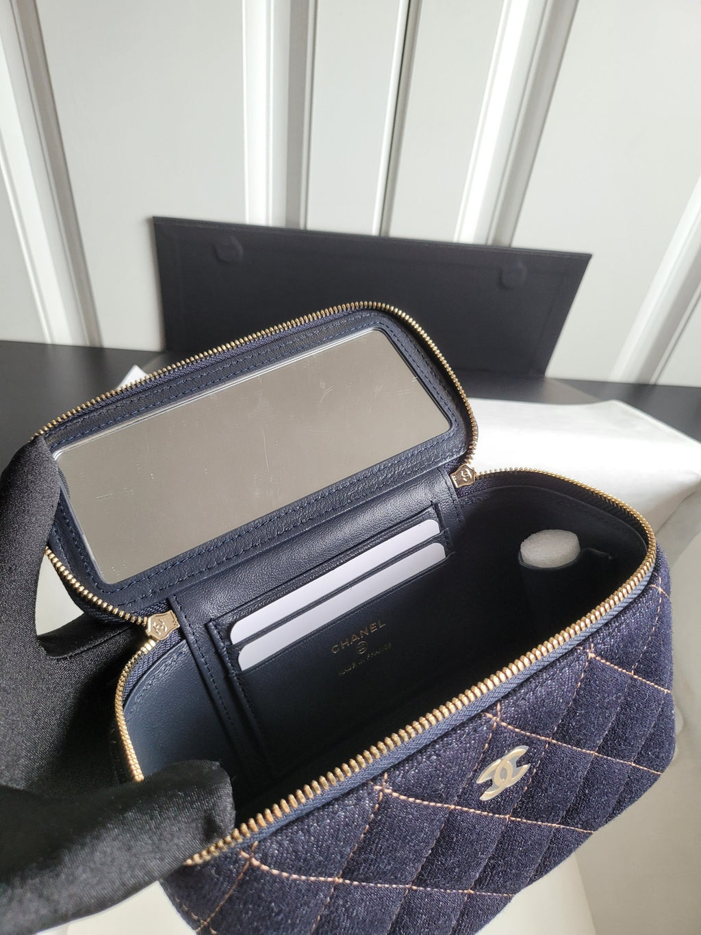 Chanel navy quilted mini bag open, showing interior pockets and zip pouch