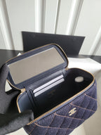 Chanel navy quilted mini bag open, showing interior pockets and zip pouch