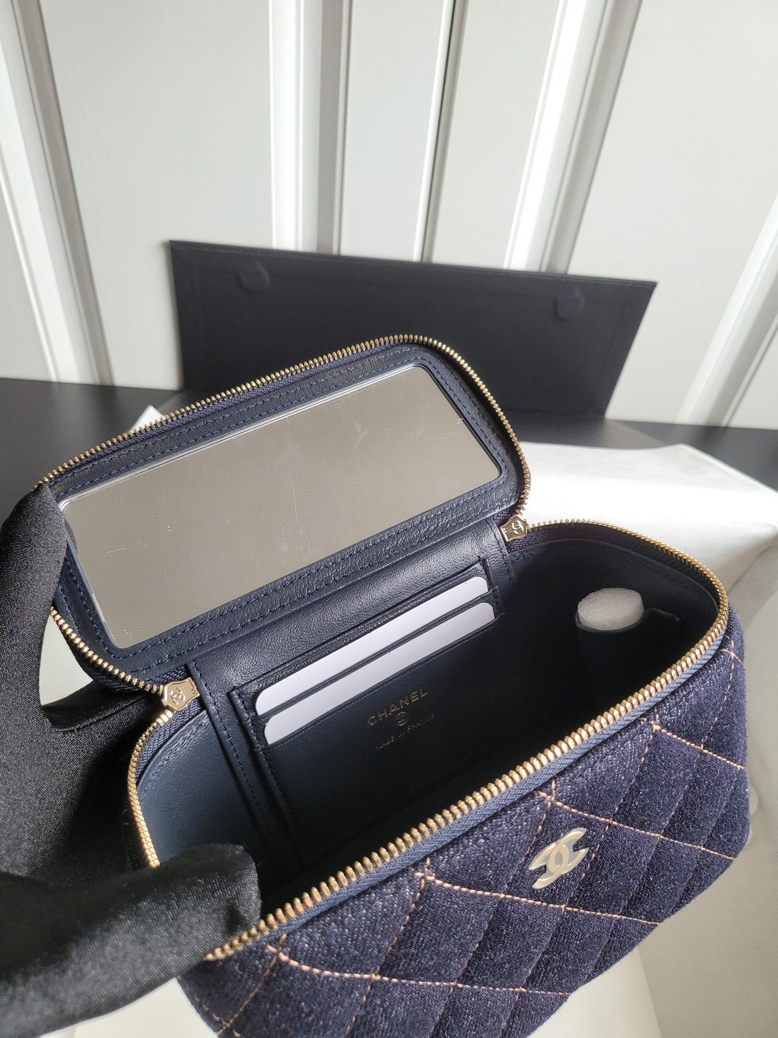 Chanel navy quilted mini bag open, showing interior pockets and zip pouch