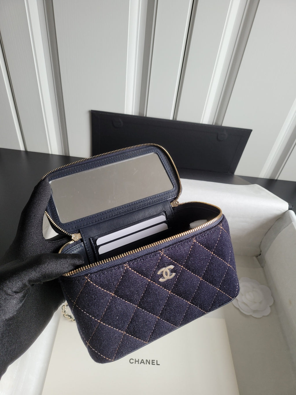 Chanel navy quilted bag open to show card slots and zip compartment