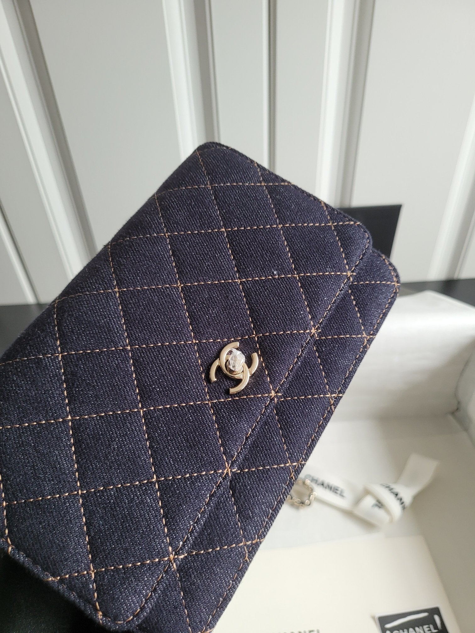 Quilted navy Chanel flap shoulder bag close-up with gold CC clasp and stitching