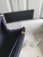 Navy Chanel bag corner with zippered pocket and gold-tone clasp at edge