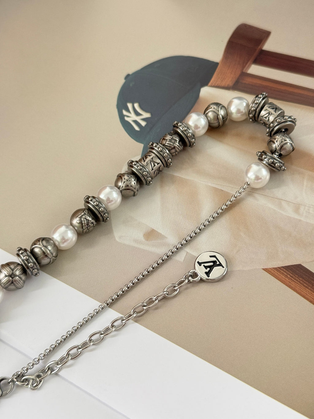 Louis Vuitton beaded bracelet with pearl-like beads and silver-tone logo stations