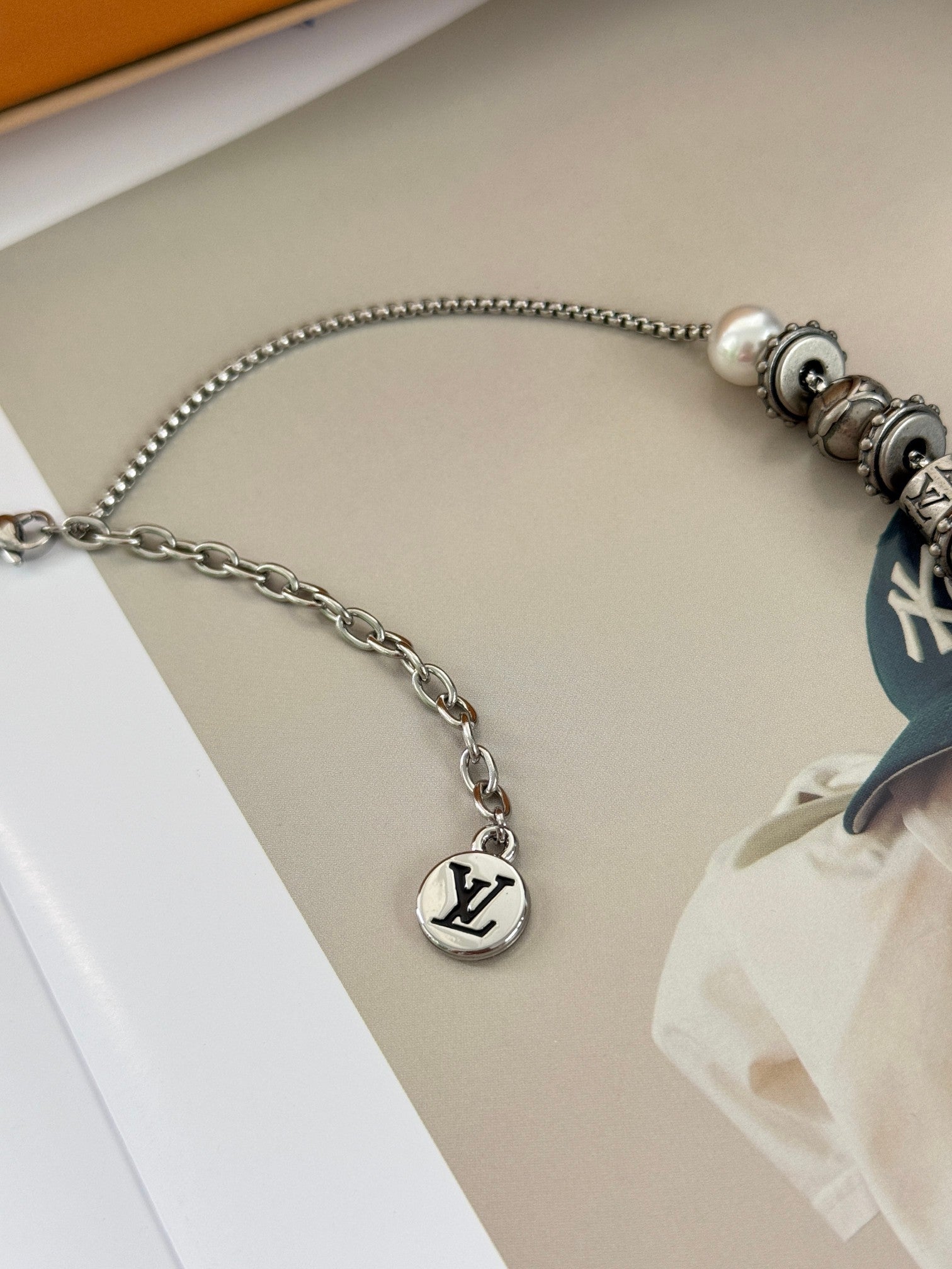 Louis Vuitton necklace close-up with silver chain and round logo charm
