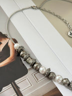 Louis Vuitton beaded necklace on model card, featuring silver-tone stations and pearls